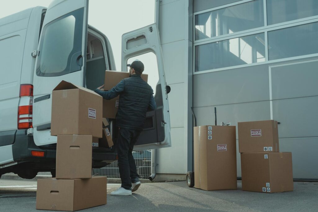 A Manatki24 employee loads cartons from the warehouse into a delivery truck during an office move in Warsaw